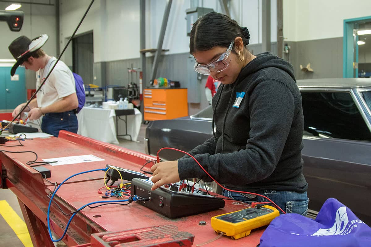 Students learning automotive and electrical engineering in a technical workshop